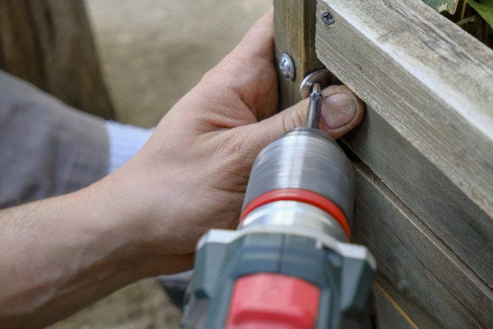 drilling bolts into wooden fence during repairs