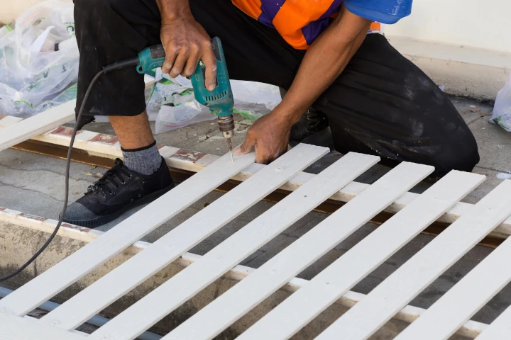 Carpenter building fence using electric drill